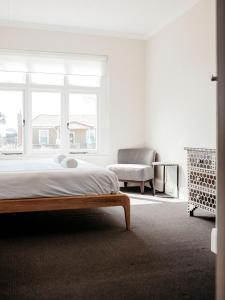 a bedroom with a bed and a chair and a window at Talina - History in the Heart of St Helens in St Helens