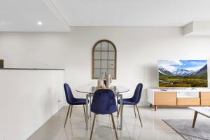 シドニーにある2BR APT Ideal for Families or Business Staysのダイニングルーム(テーブル、青い椅子付)