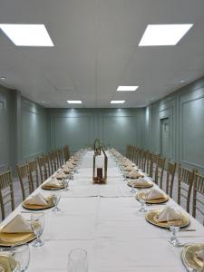 a long long table in a room with chairs and glasses at Hotel La Mansión  +28 photos