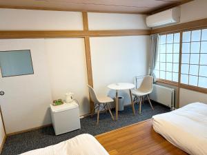 a hotel room with a bed and a table and chairs at RONENAI BASE - Vacation STAY 70567v in Shibinai