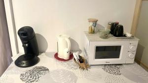 a counter top with a microwave and a blender at Studio Kumbaya in Faaa