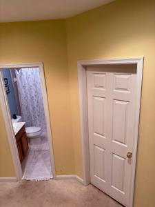 ボウイにあるWhite light retreatの白いドアとトイレ付きのバスルーム +4枚の写真