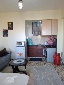 a kitchen with a couch and a table in a room at Homely studio Apartment 2 in Mombasa