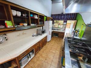 a kitchen with wooden cabinets and a white refrigerator at Mangifera Hostel in Grecia