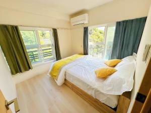 a bedroom with a bed and two windows at Ueno Sakura Inn 上野公园 in Tokyo