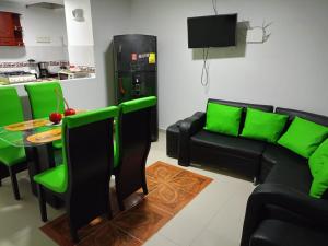 un soggiorno con divano nero e sedie verdi di Valdy hause 202 a Gaira