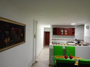 a kitchen with a table and some green chairs at Valdy hause 202 in Gaira