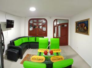 un soggiorno con un divano verde e sedie verdi di Valdy hause 202 a Gaira 1 altra foto