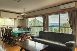 a living room with a couch and a table at 軽井沢 デッキからの眺望 BBq カラオケ IC下車5分 in Karuizawa