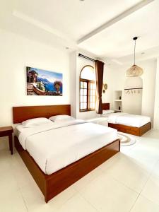 two beds in a bedroom with white walls at Villa Ramos in Tangkubanperahu +26 photos