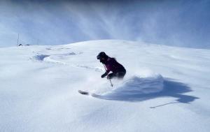 a person is skiing down a snow covered slope at Hostal La Plaça in Erill la Vall