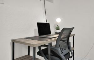 a laptop computer sitting on a desk with a chair at Suite Azul Miami - Private Guest Suite with Patio, Free Parking, Near Wynwood and Beaches in Miami +21 photos