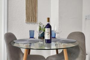 a bottle of wine sitting on a table with glasses at Suite Azul Miami - Private Guest Suite with Patio, Free Parking, Near Wynwood and Beaches in Miami