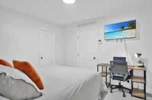 a bedroom with a bed and a desk with a tv on the wall at Suite Azul Miami - Private Guest Suite with Patio, Free Parking, Near Wynwood and Beaches in Miami