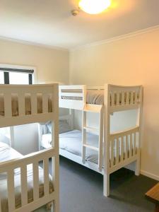 two white bunk beds in a room at House of Ullr in Thredbo