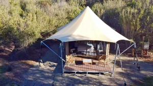 a white tent with chairs in a field at Ukiyo Nature Retreat in Fingal +2 photos