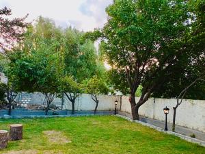 a park with trees and a wall with lights at Shah Hujra Guest House Skardu in Skardu