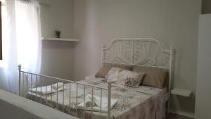 a bedroom with a white bed with a metal headboard at B&B Villa San Nicola in San Nicola Arcella