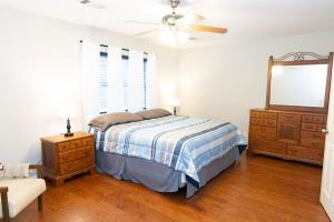a bedroom with a bed and a dresser and a mirror at 2 Bedroom Townhouse Retreat 10 min to UA Stadium in Tuscaloosa