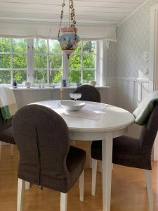 a white dining room table with chairs and a kitchen at Cosy Forest Cabin Near Bollnäs in Bollnäs