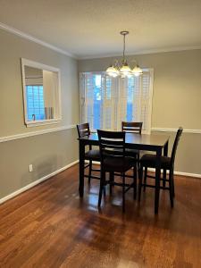 a dining room with a black table and chairs at 2 Bedroom Townhouse Retreat 10 min to UA Stadium in Tuscaloosa