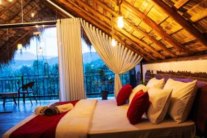 a large bed in a room with a large window at Cliff Edge Villa in Ella