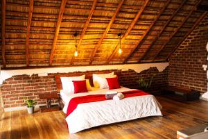 Un dormitorio con una cama en una pared de ladrillos. en Cliff Edge Villa, en Ella