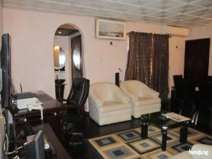 a living room with a white chair and a mirror at Sunview Hotel - akure in Akure +12 photos