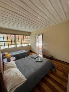 クエンカにあるBeautiful fully equipped hostel in a quiet area 5 blocks from Calderon Parkのベッドが2つと窓が2つある寝室