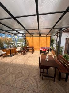 クエンカにあるBeautiful fully equipped hostel in a quiet area 5 blocks from Calderon Parkのテーブルとベンチと屋根のあるパティオ