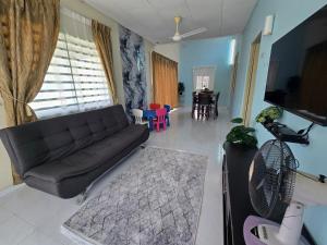a living room with a couch and a dining room at Irah Homestay in Kuantan
