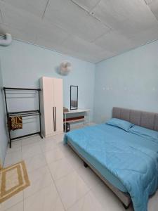 a bedroom with a blue bed and a desk at Irah Homestay in Kuantan