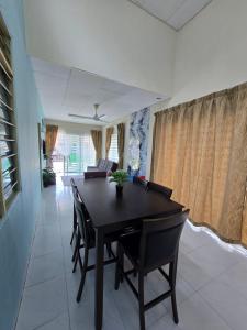a dining room with a black table and chairs at Irah Homestay in Kuantan +4 photos