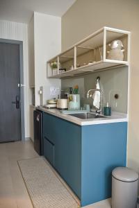 eine Küche mit einer blauen Arbeitsplatte und einer Spüle in der Unterkunft Cozy studio with Komtar view at 22 Macalisterz in George Town