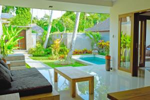 - un salon avec une piscine dans une maison dans l'établissement Villa Padma Ubud, à Ubud