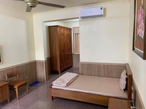 Un pequeño dormitorio con una cama y una silla. en Baviecoresort, en Ba Vì
