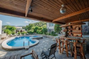 an outdoor patio with a swimming pool and a table and chairs at Villa Ananuri in Ananuri