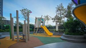 ein Spielplatz mit einer gelben Rutsche in einem Park in der Unterkunft Cozy studio with Komtar view at 22 Macalisterz in George Town