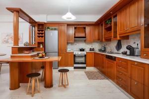 a kitchen with wooden cabinets and a table and stools at Harmony home in Ierapetra