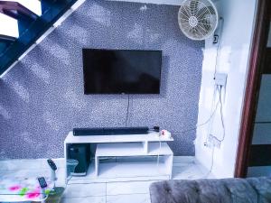 a living room with a tv on a blue wall at 2 bedroom Duplex at Kisimani Heights Apartments, Nyali, Mombasa in Mombasa +17 photos