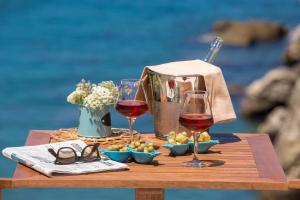 una mesa con dos copas de vino y comida. en Relais Regina Giovanna, en Sorrento