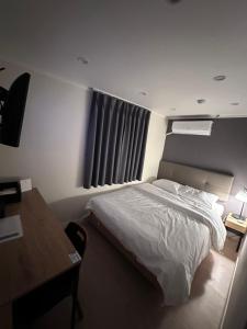 a bedroom with a bed and a desk and a desk at About Stay Dongdaemun in Seoul