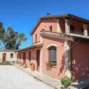 a pink building with a balcony on a street at La Casa dei Tigli in Cannara