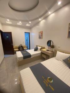 una habitación de hotel con dos camas y una mesa en Hạ Long Xanh, en Hanói
