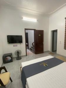 Una habitación de hotel con una cama y un televisor. en Hạ Long Xanh, en Hanói
