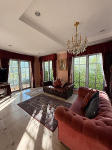 a living room with a couch and a chandelier at Villa de Jano in Ban Muang Pha