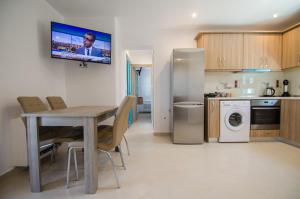a kitchen with a table and chairs and a refrigerator at Ios Sea View in Ios Chora