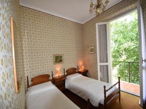 two beds in a room with a window at Belle Epoque Belvilla by OYO in Meina