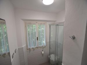 a bathroom with a shower and a toilet and a window at Belle Epoque Belvilla by OYO in Meina +18 photos