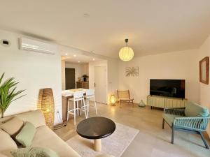 ein Wohnzimmer mit Sofa und Tisch in der Unterkunft Appartement Club Ocean in L'Ermitage-Les-Bains